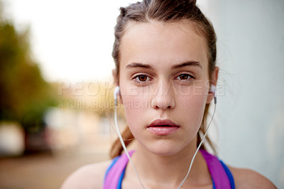 Buy stock photo Portrait, earphones and teenager with fitness music, radio and listening to motivation playlist outdoor. Audio, athlete and serious girl streaming sound, song and exercise podcast with determination