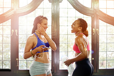 Buy stock photo Laugh, friends and women in gym with music for exercise, workout and training together in morning. Happy, fitness and people with funny joke, conversation and chat with earphones for sports playlist