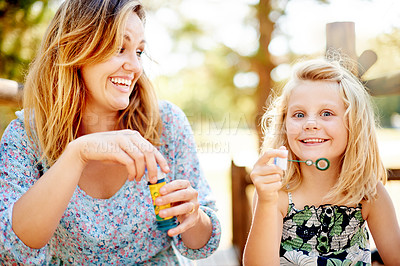 Buy stock photo Bubbles, mother and child in park for bonding, together and outdoor for fun. Soap toy, girl and woman in garden with summer portrait, holiday and daughter with care and play in nature for weekend