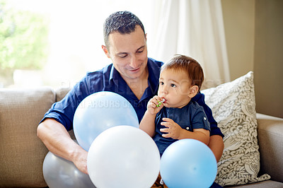 Buy stock photo Dad, son and smile with party whistle for birthday, childhood or bonding on sofa in home. Father, child and horn for celebration, love and fun in living room of house for event together with balloons