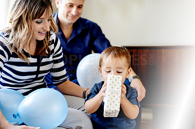 Buy stock photo Birthday, present and family with child, lounge or parents with toddler for celebration in apartment. Happy, man and woman with son in home, love and gift for first party, growth and development