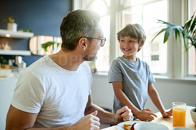 Buy stock photo Breakfast, smile and dad with child in kitchen in home with bonding, laughing and wellness. Happy, health and father with boy kid for eating healthy morning meal together with connection in house.