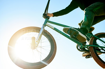 Buy stock photo Bike, air and person with trick by blue sky with lens flare, jump or stunt for extreme sports outdoor. Skill, action and below athlete on bicycle for fitness, cyclist challenge or rider with talent