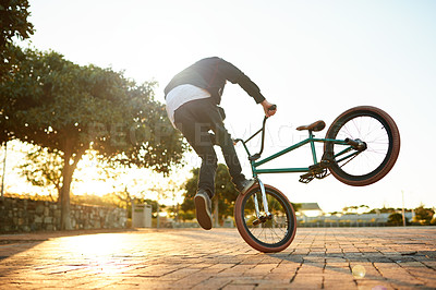 Buy stock photo Man, bike and trick in city with talent at sunset, stunt or performance for extreme sports outdoor. Skill, action and back of athlete on bicycle for fitness, urban cyclist challenge or rider flip