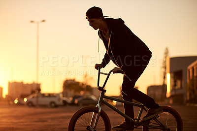 Buy stock photo Urban, skill and man on bicycle for sunset, sports training and travel in city street to practice. Cool male person, evening or stunt biker in town for holiday, exercise or outdoor cycling activity