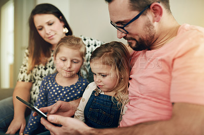 Buy stock photo Parents, children and relax on sofa with tablet, bonding and choice for movies in family home. People, mom and dad with girl kids, tech or app for subscription, film or streaming service at house