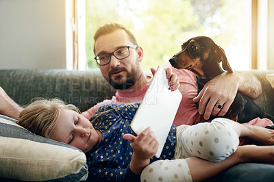 Buy stock photo Dog, father and daughter in home with tablet, online scroll or video binge on digital app. Relax, bonding together and family on sofa with technology, movie streaming or virtual browsing with pet.