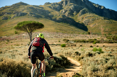 Buy stock photo Back, bike and off road with man in mountains for outdoor exercise, fitness or hobby. Journey, space and trail with person cycling in scenic nature for challenge, performance or sports training