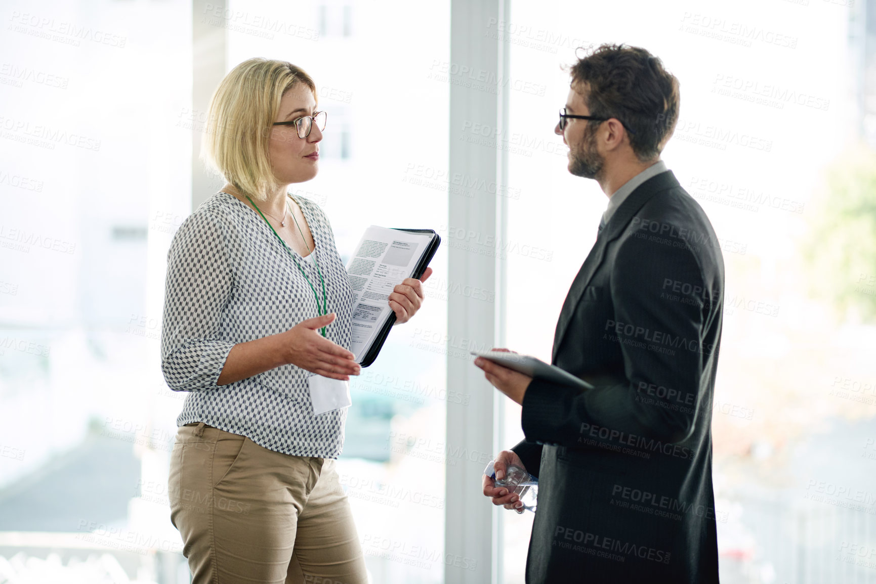 Buy stock photo Communication, manager or employee at window with tablet for feedback, collaboration or project review. Digital app, discussion or business people in workplace with tech, teamwork or strategy meeting