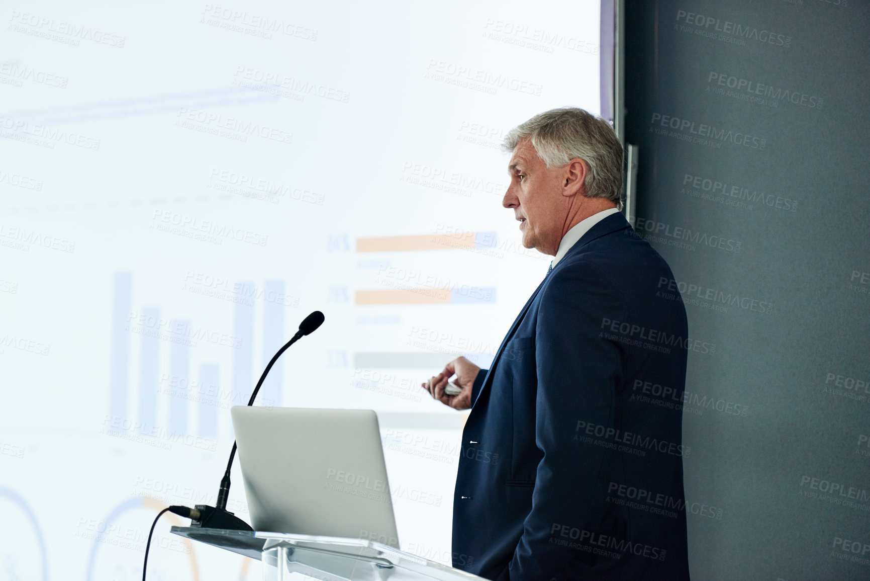 Buy stock photo Mature businessman, presentation and finance at seminar with charts, results and info at company. Person, leader and speaker on stage, projector and point with revenue announcement at conference