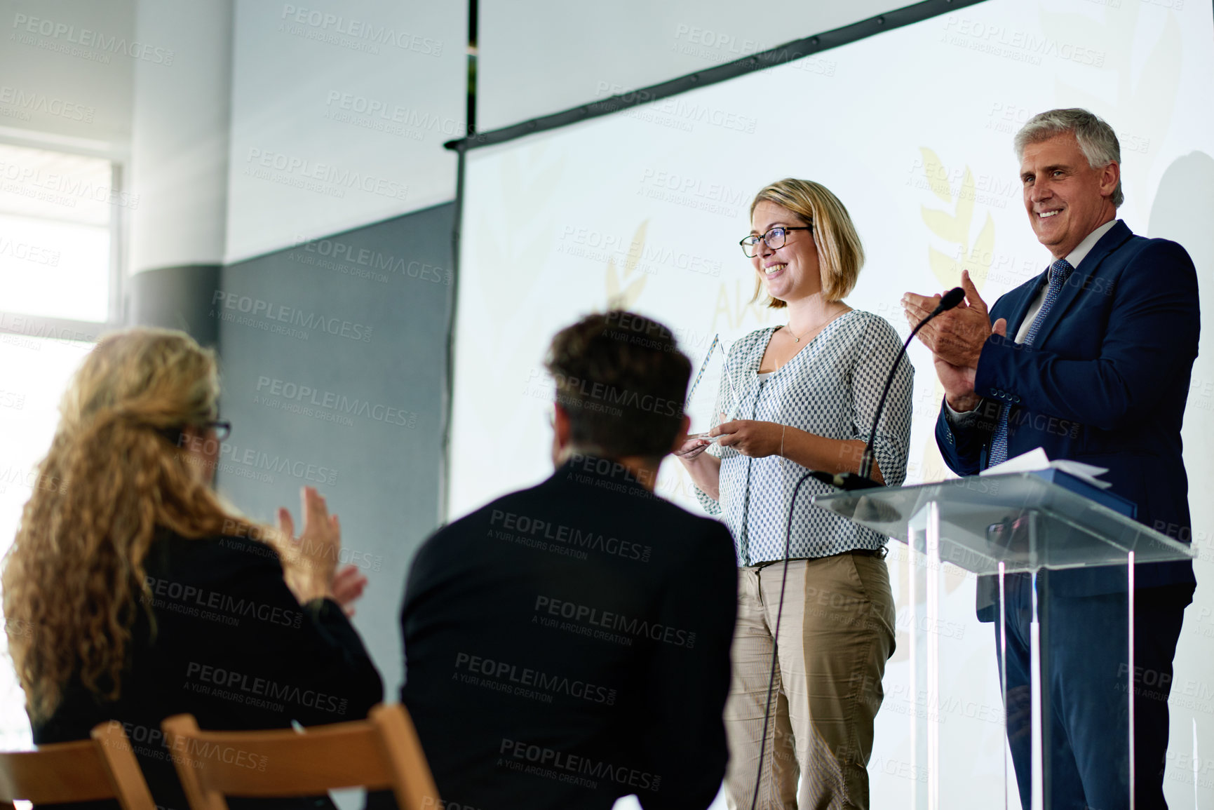 Buy stock photo Trophy, success and presentation with business people and podium for achievement, congratulations and winner. Thank you, applause and nomination prize with employees at ceremony for recognition
