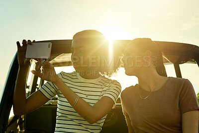 Buy stock photo Photography, phone and car with women on road trip together for holiday, travel or vacation. Memory, nature and social media with happy friends outdoor for profile picture with flare and destination