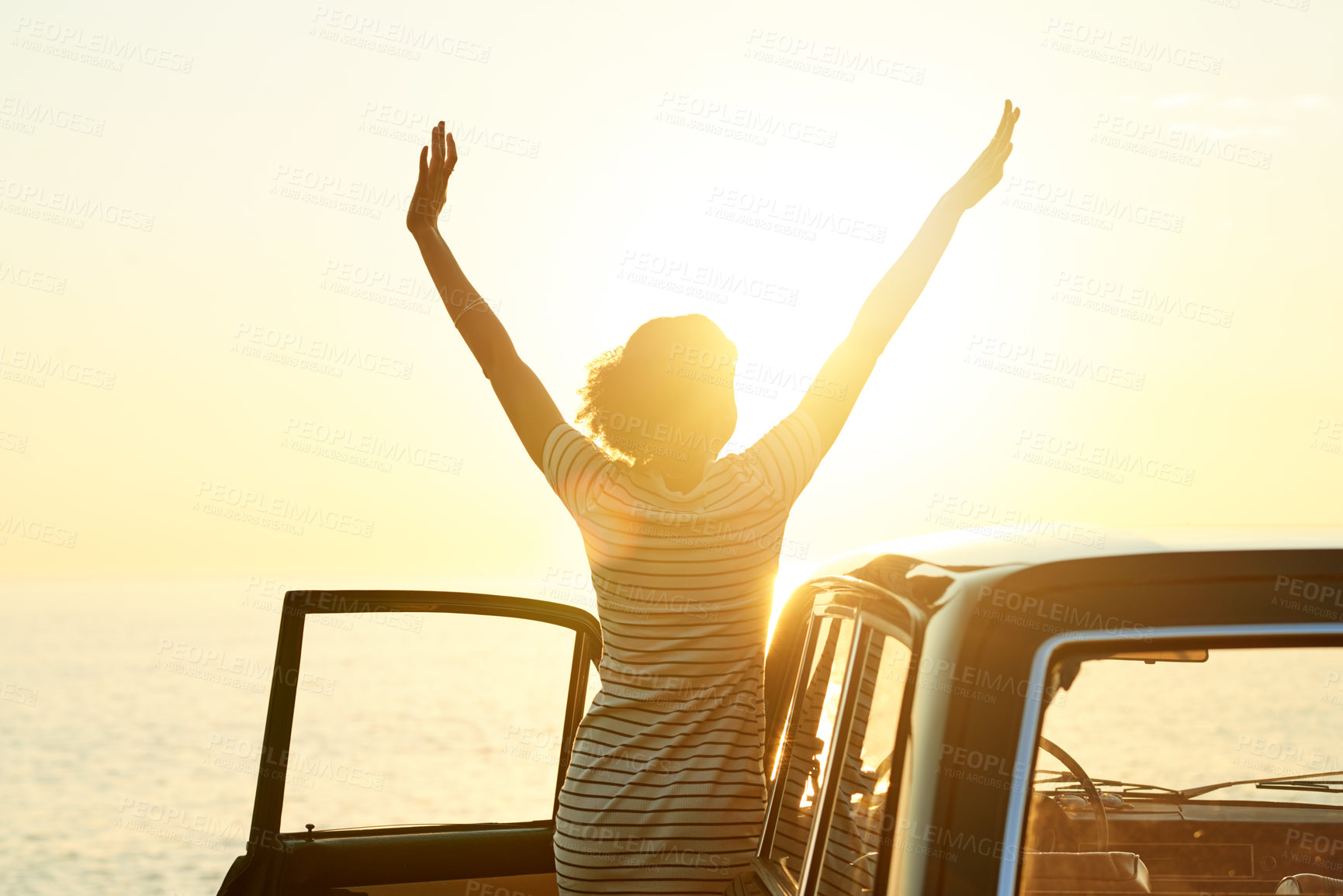 Buy stock photo Shot of a happy young woman enjoying a road trip