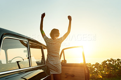 Buy stock photo Shot of a happy young woman enjoying a road trip