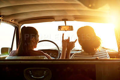Buy stock photo Shot of two young women enjoying a road trip