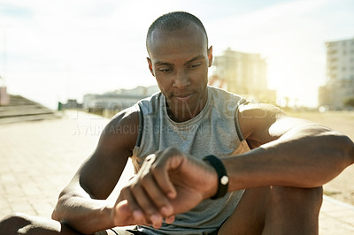 Buy stock photo Black man, smart watch and check stats in city, break and stopwatch for fitness, exercise and training. Person, runner and rest with clock, timer or app for heart rate for cardio challenge in Kenya