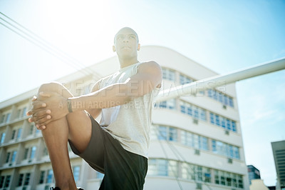 Buy stock photo Man, low angle and stretching legs for fitness, warm up and city for cardio preparation. Male person, urban street and athlete for workout, getting ready and exercise for marathon training with flare