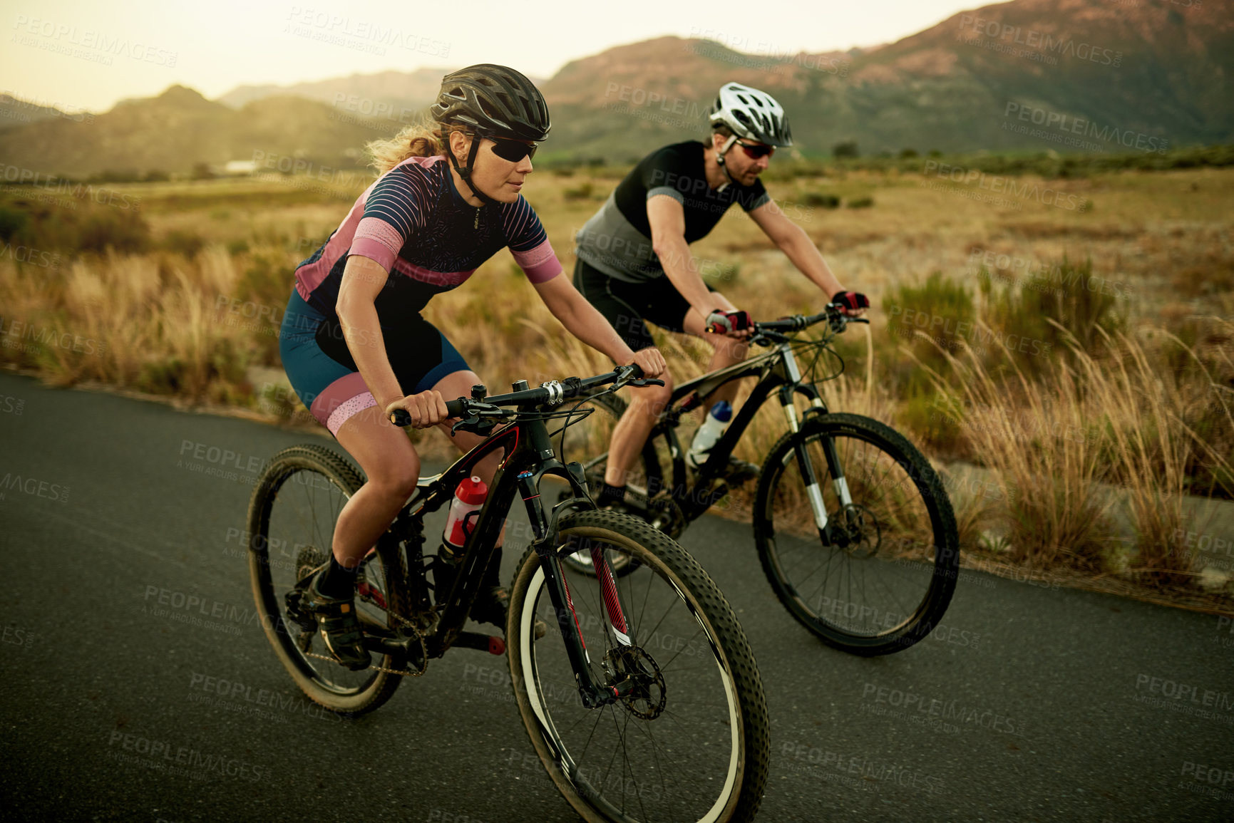 Buy stock photo Couple, cycling or road with bike in nature for fitness, exercise or outdoor workout together. Active man, woman or cyclist with bicycle on street or asphalt for race or sport marathon in countryside