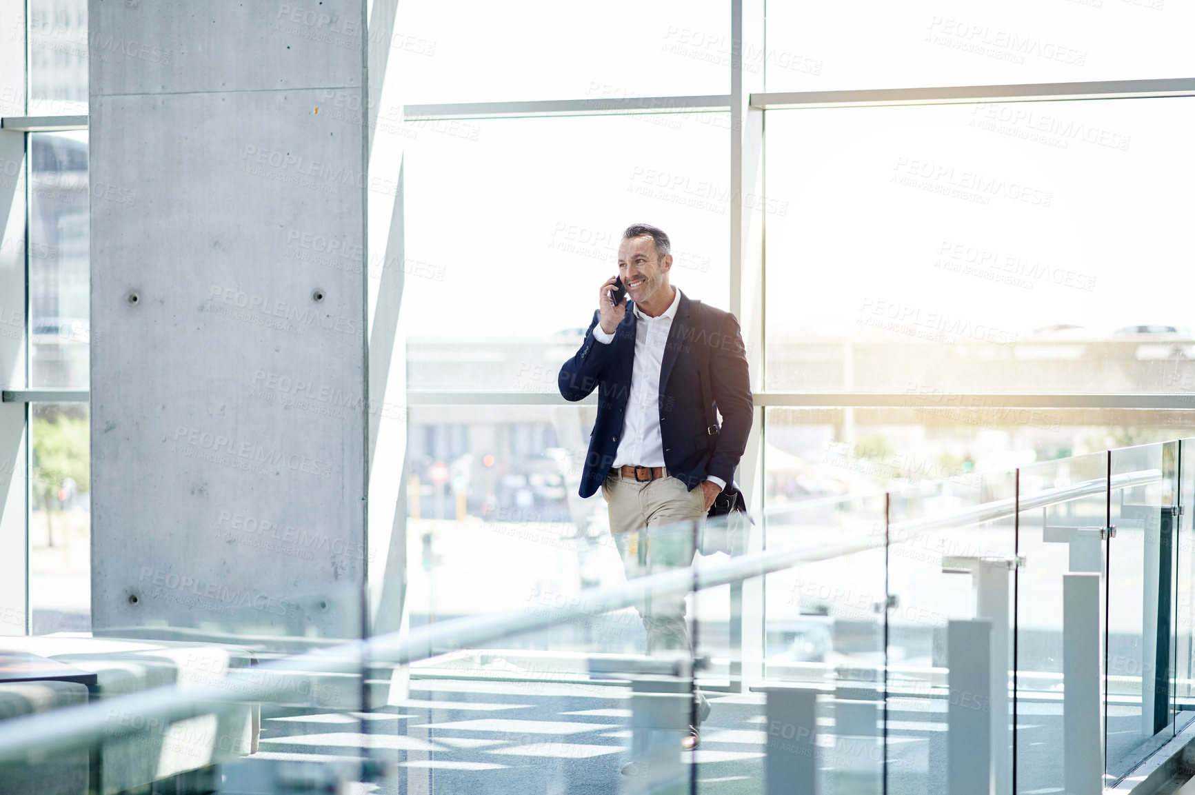 Buy stock photo Phone call, smile and walking with business man in foyer for feedback, negotiation or update. Communication, conversation and thinking with mature employee in lobby of office for project management