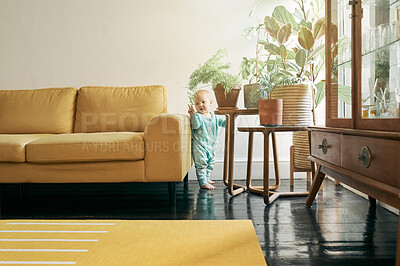 Buy stock photo Baby, living room and walk learning of a young child at home with mobility development alone.  Balance, curious and standing toddler in house lounge ready for walking and first steps without support