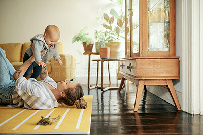 Buy stock photo Family, play and mama lift baby in home for bonding, quality time and relax together on floor. Living room, love and happy mother with kid playing for child development, care and happiness on weekend