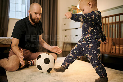 Buy stock photo Soccer, bedroom and a father playing with his baby boy in the nursery of a home together in the morning. Football, family and kids with an infant child kicking a ball to his male parent in a house