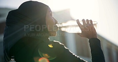 Buy stock photo Muslim, drinking and black woman with water for outdoor fitness, workout break or hydration. Active, female person or profile with mineral liquid, bottle or beverage for recovery or rest in city