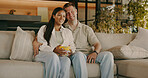 Popcorn, happy and couple on sofa with for watching tv. movie and streaming to relax on weekend. Marriage, home and man with woman with snack, series and film for bonding and interracial relationship