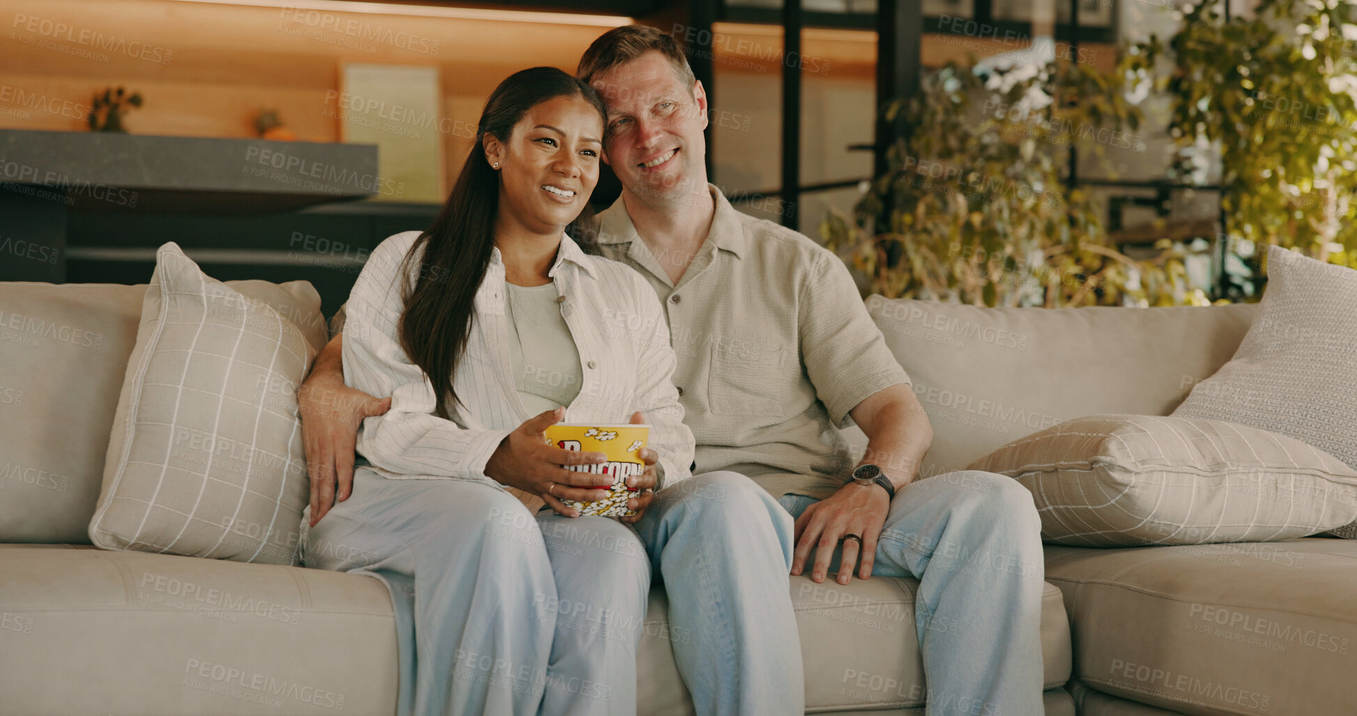 Buy stock photo Popcorn, happy and couple on sofa with for watching tv, movie and streaming to relax on weekend. Marriage, home and man with woman with snack, series and film for bonding and interracial relationship