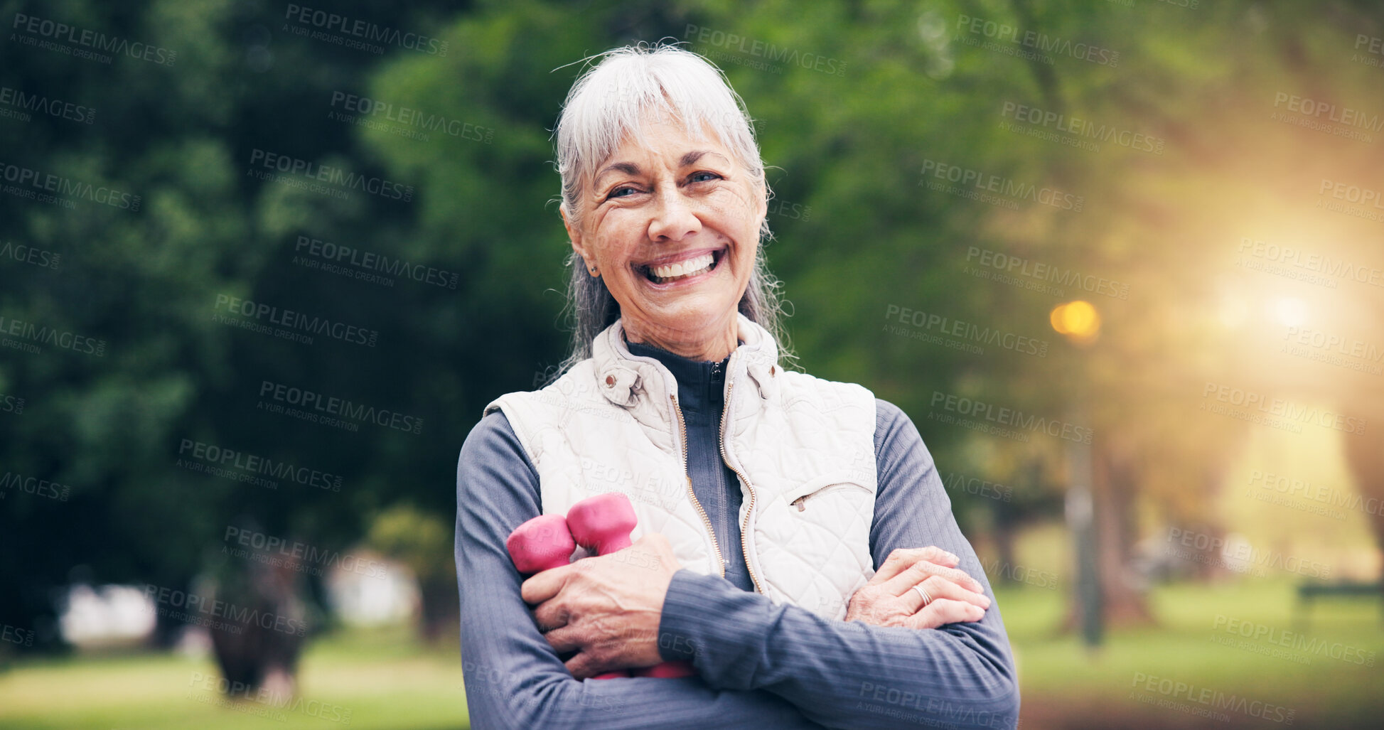 Buy stock photo Portrait, old woman and smile in nature for fitness, exercise and training for healthy lifestyle. Flare, senior person and arms crossed at park with dumbbells, workout and stress relief for wellness