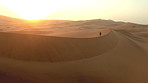 Walking at sunrise over the desert