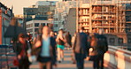 A group of people walking over the bridge while someone is working out in the morning.