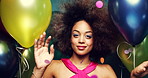 Young african american woman enjoying a party dancing between colourful balloons. Happy carefree woman dancing between colourful confetti and balloons celebrating at a party