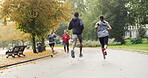 Group of diverse businesspeople jogging through the park. Back of two fit friends running through the park in slow motion. Two people doing cardio exercise, jogging through a garden