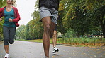 A diverse group of friends running through the park together. A group of young sporty people running in the garden during a cardio training exercise together. A group of friends jogging together