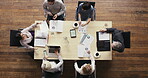 a group of businesspeople having a meeting in a modern office. A group of businesspeople brainstorming in a meeting in a boardroom, reading paperwork from above. Colleagues in marketing meeting