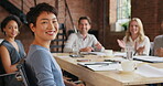 a young businesswoman having a meeting with her colleagues in a modern office. Happy young asian businesswoman sitting in a boardroom during a meeting with her coworkers clapping and celebrating.