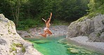 Woman in a white bikini jumping into a lake to swim. Young woman on holiday swimming in a lake after jumping from a cliff. Woman in a white bikini swimming in a lake