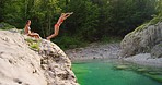Excited young woman jumping into a lake with excitement. Young woman jumping into a lake to swim on holiday with her friend. Two friends on holiday swimming in a lake