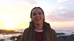 A cheerful young woman laughing and enjoying the sunset on the promenade. A carefree young woman on holiday enjoying herself on the promenade. A young woman in pigtails laughing on the beach