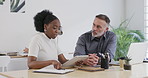 African american business woman working on a digital tablet next to her boss. Young black woman discussing work with a mature manager or supervisor in the office. Running ideas by the project head