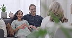 Couple talking to a therapist inside a room. Man and pregnant woman sitting down on a couch having a discussion with a professional. Couple expecting a baby getting counselling