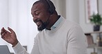 Happy mature male call center agent wearing a headset and answering calls while working on a laptop at home. Cheerful male customer service agent talking on a call and using a laptop