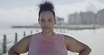 Portrait of plus size runner standing alone in city. Smiling active mixed race woman getting fit, losing weight with routine outdoor jogging. Happy confident hispanic feeling successful achieving goal