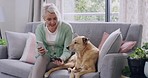 One senior woman using cellphone and credit card while doing online shopping and banking from device at home while bonding with pet dog in lounge at home. Retired woman spending money from smartphone