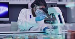 African american scientist using a microscope in a research laboratory testing different samples of viruses. A doctor wearing mask experiments with blood samples in a scientific healthcare facility
