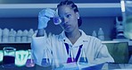 Scientist mixes organic liquid in a flask in a laboratory. Professional biochemist testing various fluids and analyzing the results for her project in a research lab. Testing chemicals in a cylinder
