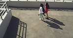 Two young female athletes getting ready to exercise together at stadium. Sporty friends and teammates arriving at a field to train from above. Sporty woman preparing for a workout at a sports club