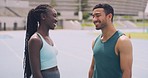 Friendly male and female athletes talking and having fun after training. Portrait of happy athletic man and woman smiling and chatting. Funny sports people discussing a training session outdoors