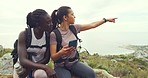 Two women using a phone GPS to look for directions on a hill. Ladies are lost and can't find their way back from where they started. Female hikers stuck on a hiking trail in nature on a mountain